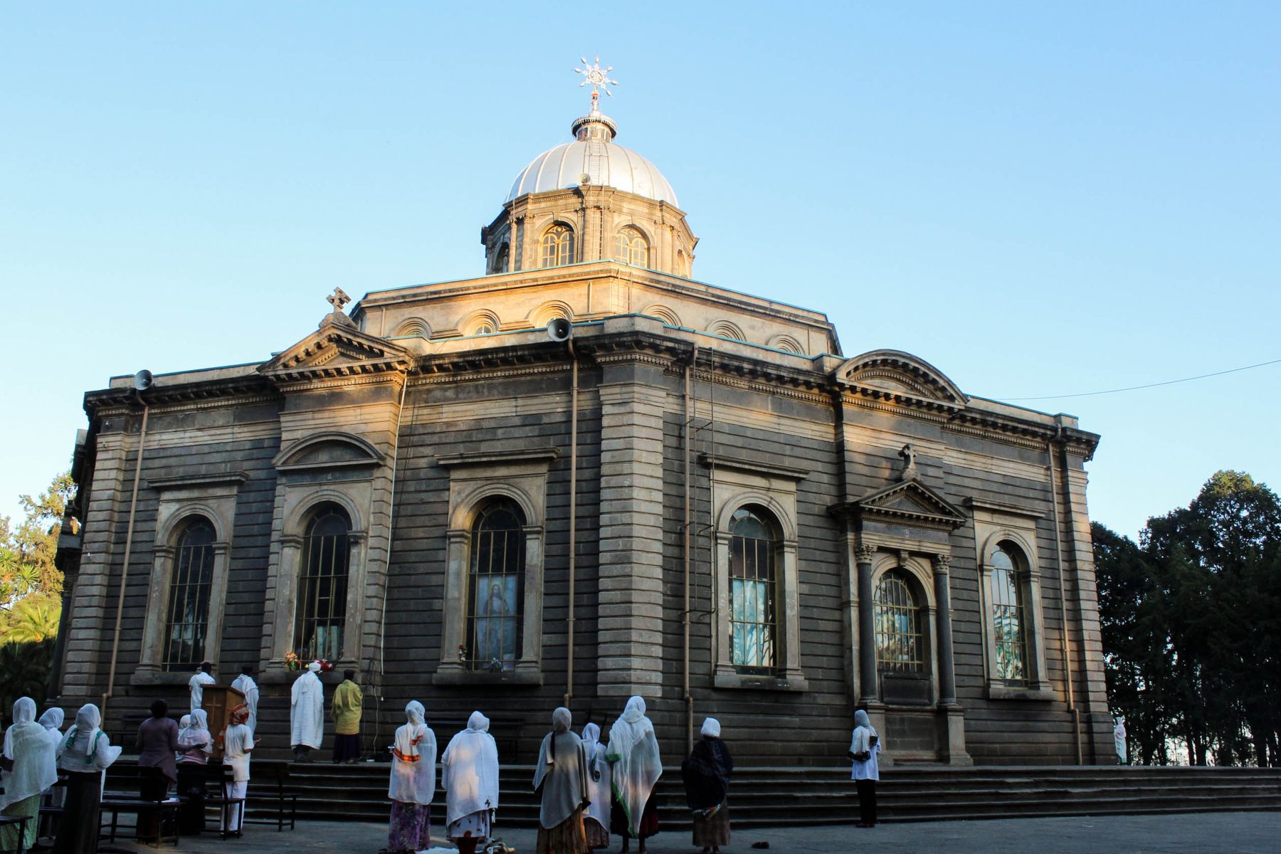 Ethiopian Orthodox worshippers walking outside a historic cathedral in Addis Ababa