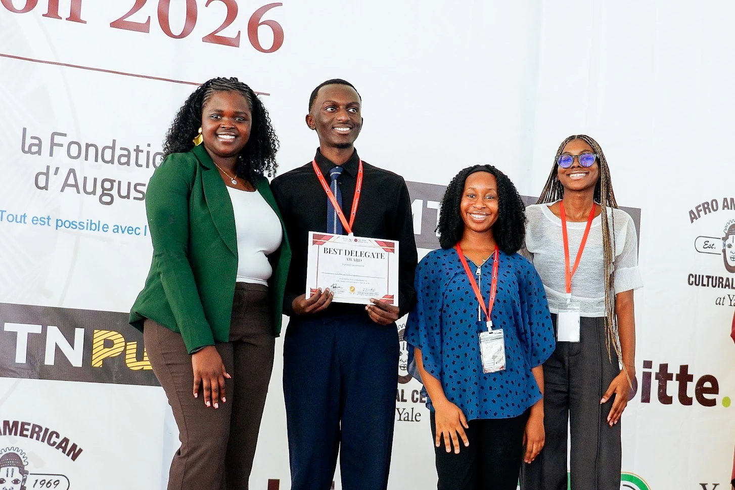 A YMAU V committee award recipient standing with conference leaders