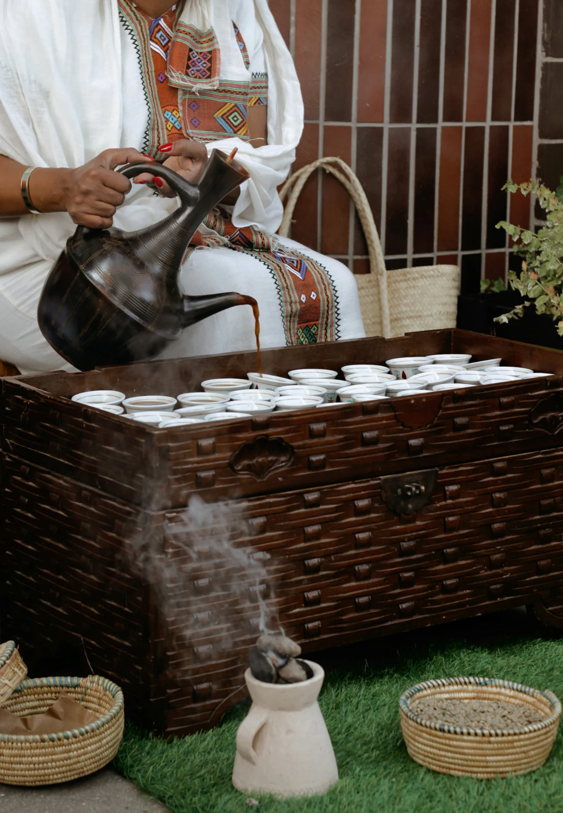 Coffee being poured from a traditional Ethiopian jebena into small cups
